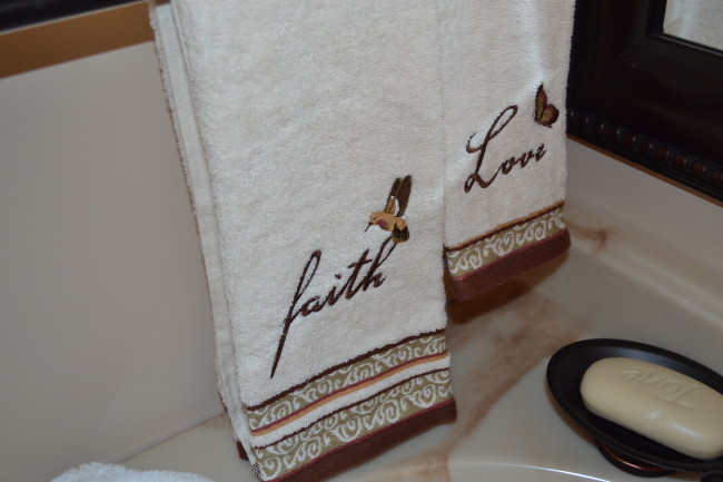 Decorative touches of embrodiered towels to match shower curtain