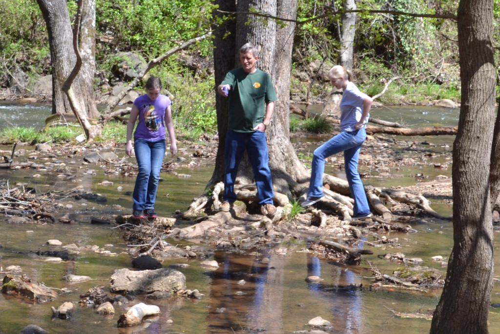 My daughter, her dad, and her friend enjoy jumping rocks in a natural sanctuary.